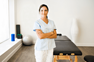 A woman standing in front of a massage table