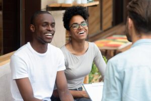 Happy African American Young Family Couple Listen To Counselor Psychologist