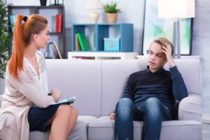 Depressed teenager having therapy session with therapist